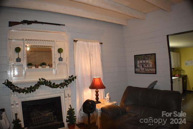 living room with beamed ceiling and a large fireplace