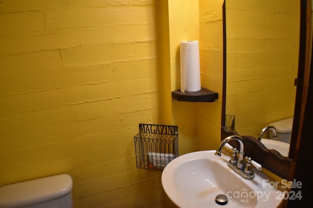 306 Mcadenville Rd, Lowell, NC 28098 - bathroom featuring a sink and concrete block wall