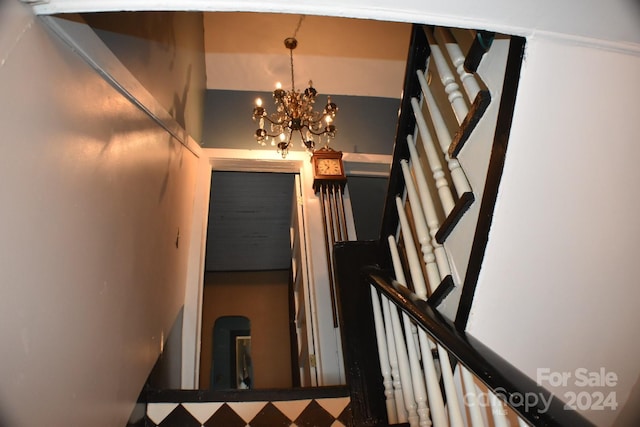 staircase featuring a chandelier