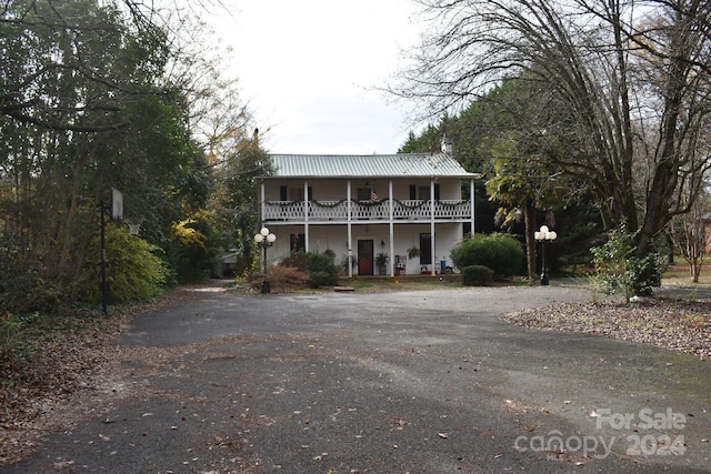 front facade featuring a porch and a balcony