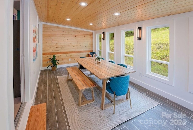 dining area with wooden walls, wooden ceiling, and vaulted ceiling