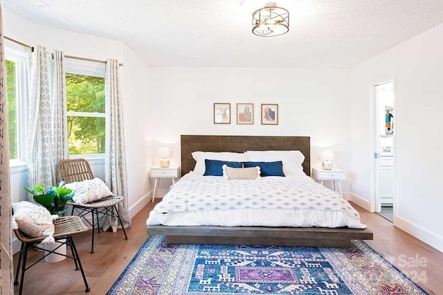 bedroom featuring wood-type flooring and a textured ceiling