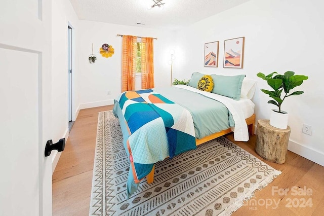 bedroom with hardwood / wood-style flooring and a textured ceiling