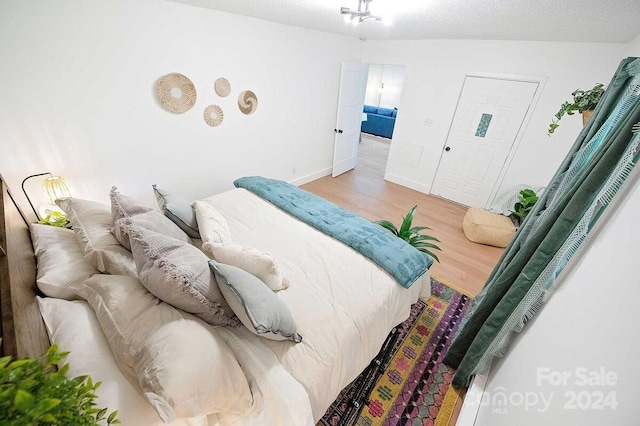 bedroom with hardwood / wood-style flooring and a textured ceiling