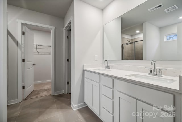 bathroom featuring tile patterned flooring, vanity, and a shower with door