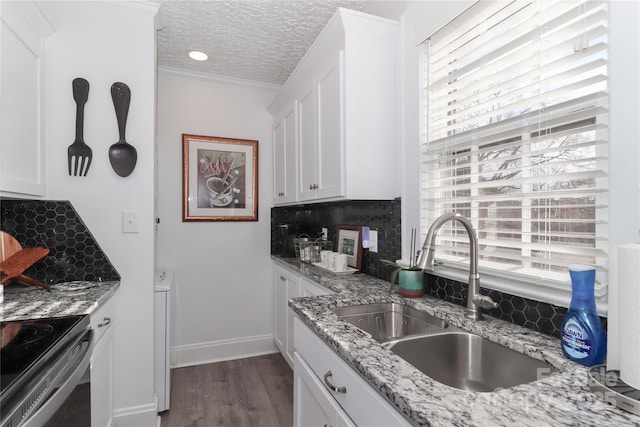 kitchen with tasteful backsplash, sink, white cabinets, and a textured ceiling