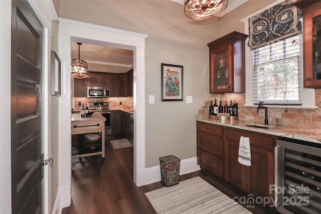 bar with sink, tasteful backsplash, decorative light fixtures, stainless steel appliances, and beverage cooler