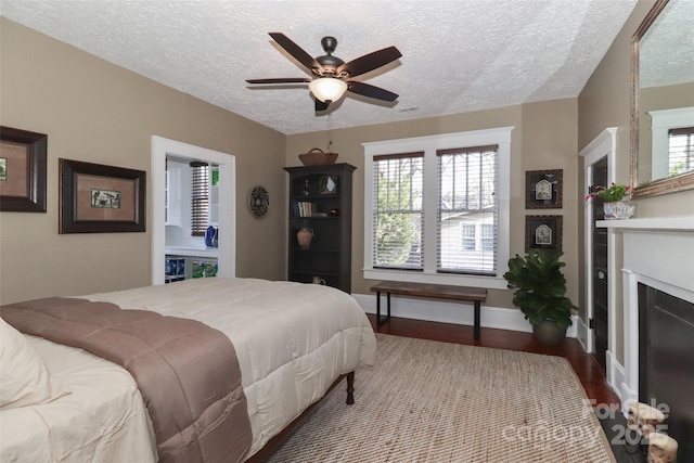 bedroom featuring light wood-type flooring, a textured ceiling, and ceiling fan