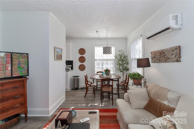 living room with a textured ceiling, hardwood / wood-style flooring, a wall unit AC, and crown molding