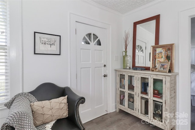 foyer entrance with crown molding, a textured ceiling, and dark wood-type flooring