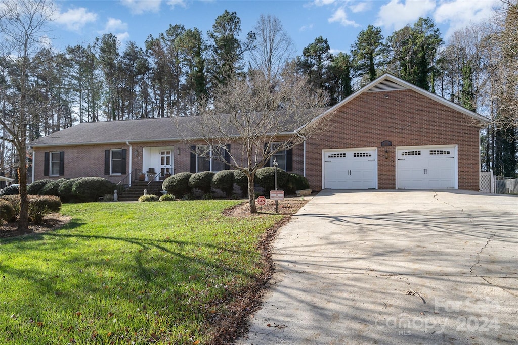 single story home featuring a garage and a front yard