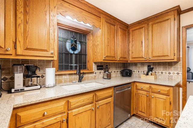 kitchen featuring stainless steel dishwasher, light stone countertops, sink, and tasteful backsplash