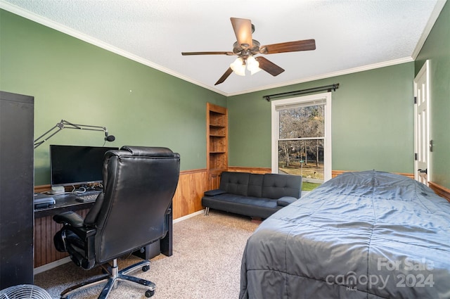 bedroom featuring wood walls, crown molding, carpet flooring, ceiling fan, and a textured ceiling