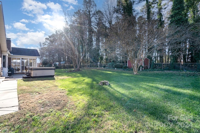 view of yard featuring a hot tub and a storage unit