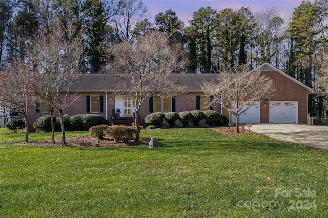 single story home featuring a yard and a garage