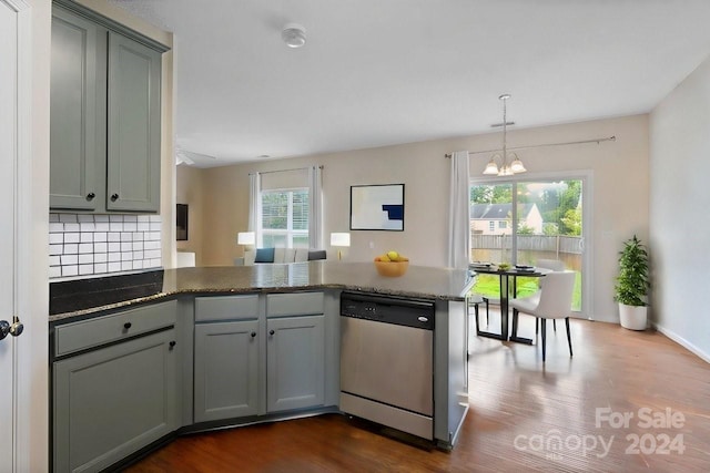 kitchen with dishwasher, dark hardwood / wood-style floors, kitchen peninsula, and a chandelier