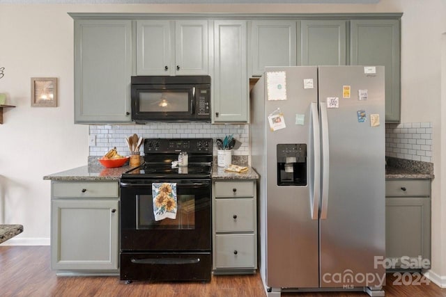 kitchen featuring decorative backsplash, light wood-type flooring, and black appliances