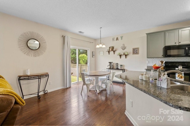 dining space with a chandelier, a textured ceiling, dark hardwood / wood-style flooring, and sink