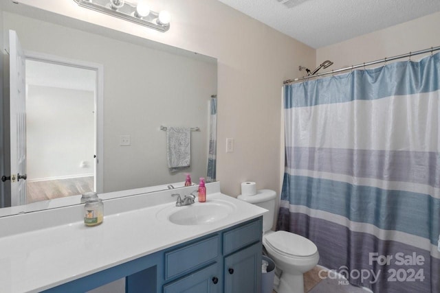 bathroom featuring a shower with curtain, hardwood / wood-style floors, a textured ceiling, toilet, and vanity