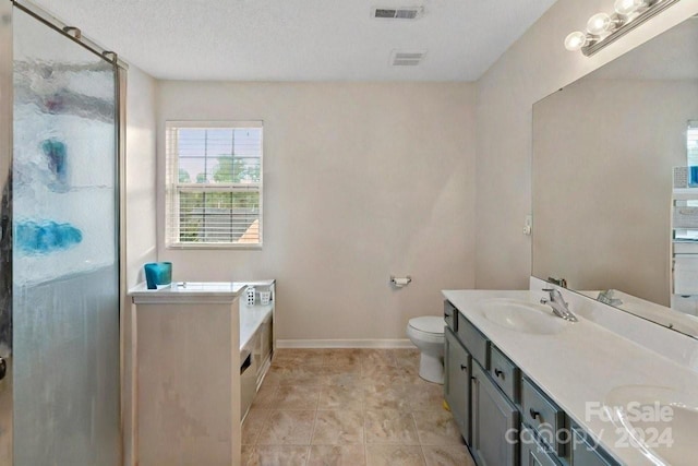 full bathroom featuring vanity, a textured ceiling, toilet, and separate shower and tub