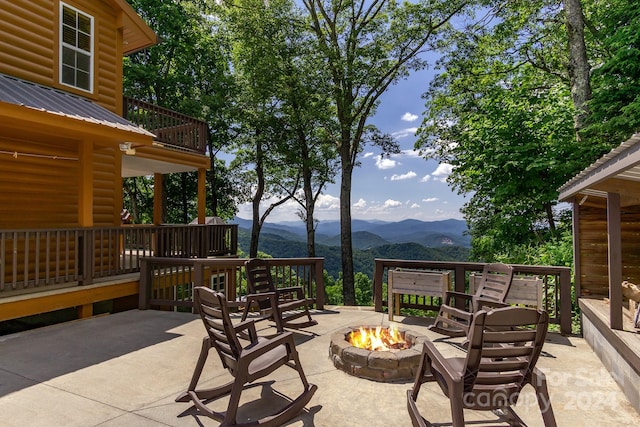 view of patio / terrace with a mountain view, a balcony, and an outdoor fire pit