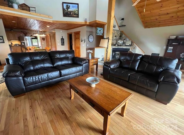 living room with a fireplace, light hardwood / wood-style flooring, wood ceiling, and vaulted ceiling