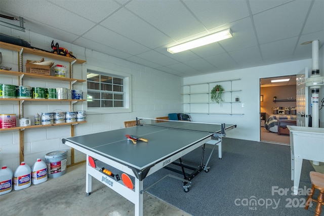 playroom featuring concrete flooring and a drop ceiling