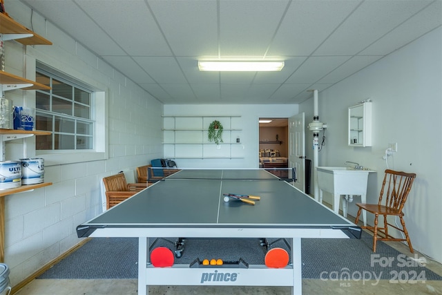 rec room featuring concrete flooring and a drop ceiling