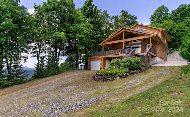 log-style house with a wooden deck and a garage