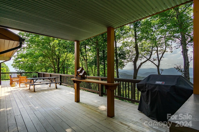 wooden deck featuring a mountain view and area for grilling