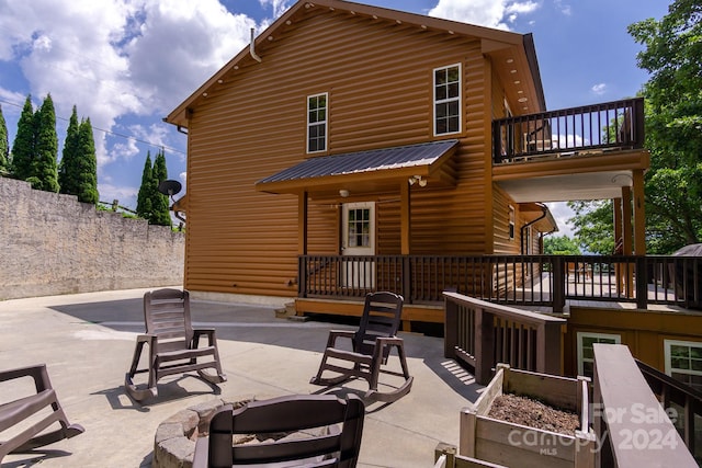 rear view of property featuring a patio area and a balcony