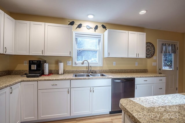 kitchen featuring dishwasher, light hardwood / wood-style floors, white cabinetry, and sink