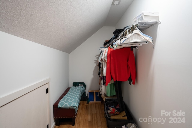 walk in closet with hardwood / wood-style flooring and lofted ceiling