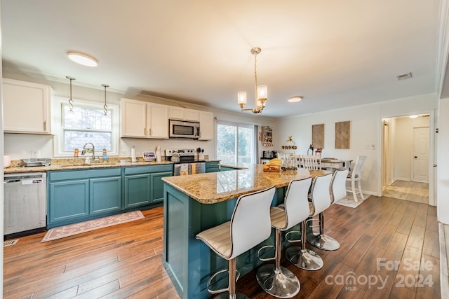 kitchen with decorative light fixtures, white cabinetry, stainless steel appliances, and dark wood-type flooring