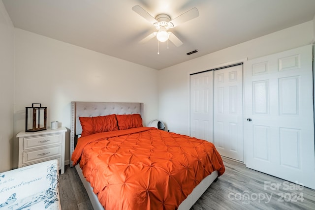 bedroom featuring ceiling fan, a closet, and light hardwood / wood-style floors