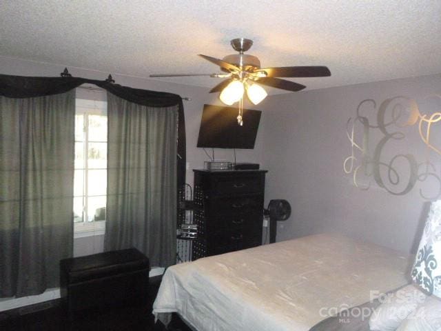 bedroom with ceiling fan and a textured ceiling