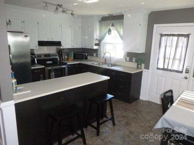 kitchen featuring a breakfast bar area, white cabinetry, sink, and appliances with stainless steel finishes