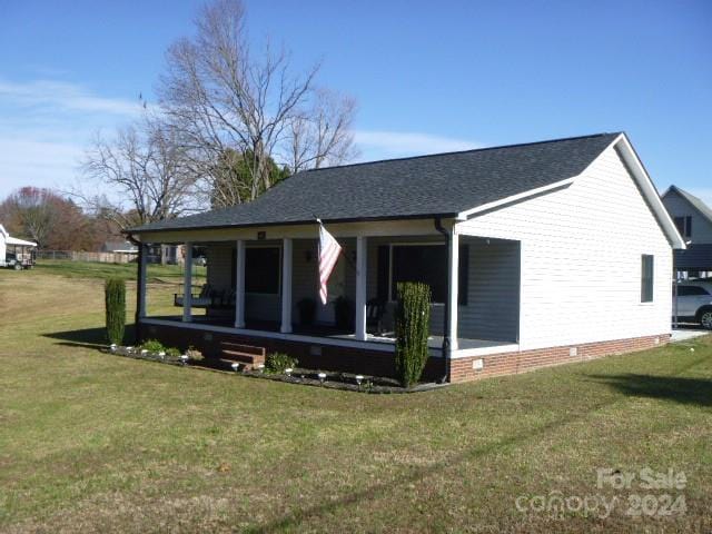 view of side of property with a sunroom and a lawn