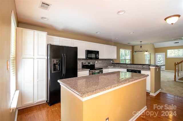 kitchen featuring black appliances, white cabinets, decorative light fixtures, a kitchen island, and kitchen peninsula