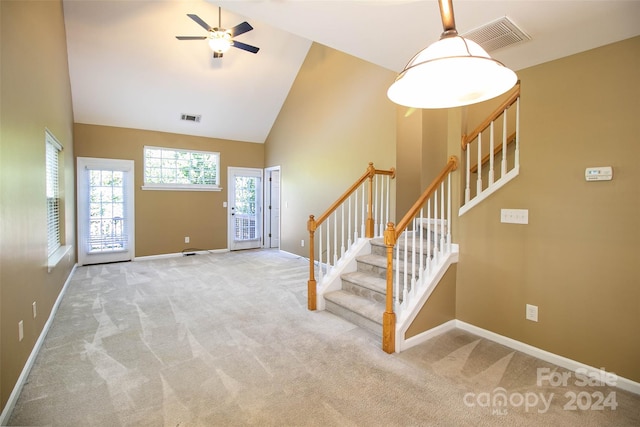 foyer featuring light colored carpet, high vaulted ceiling, and ceiling fan