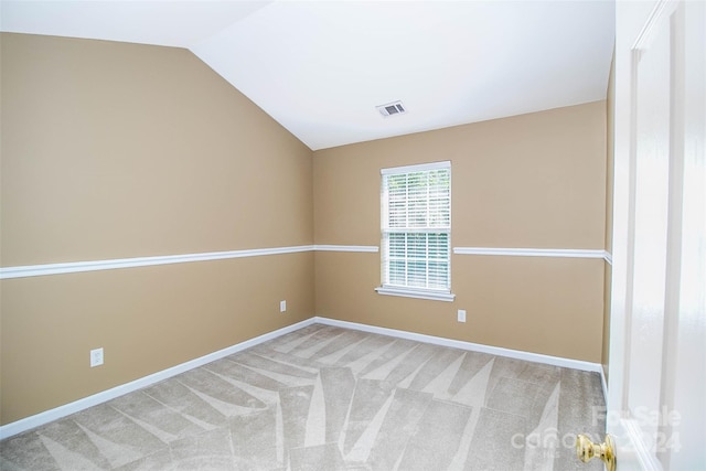 empty room featuring light carpet and lofted ceiling