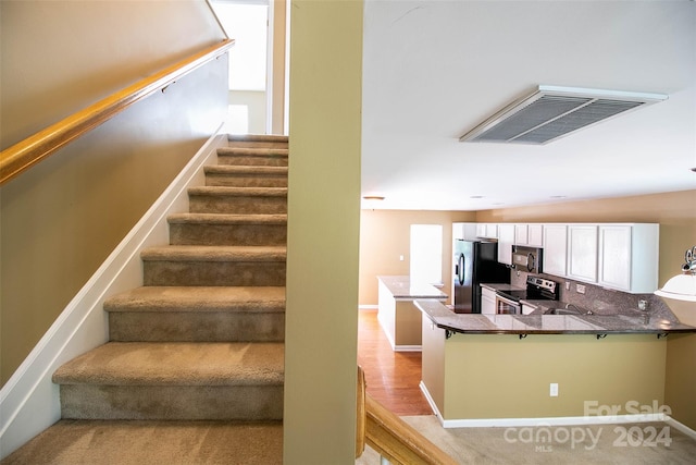 stairs featuring lofted ceiling and hardwood / wood-style flooring