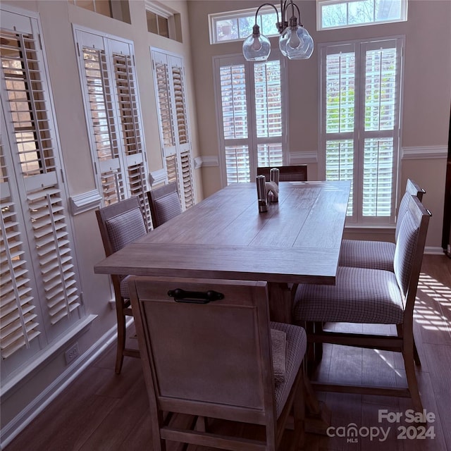 dining space with dark hardwood / wood-style floors and an inviting chandelier