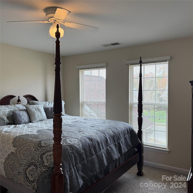 carpeted bedroom featuring multiple windows and ceiling fan