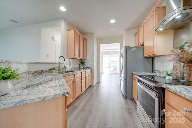 kitchen with sink, wall chimney exhaust hood, light brown cabinets, light stone counters, and electric stove