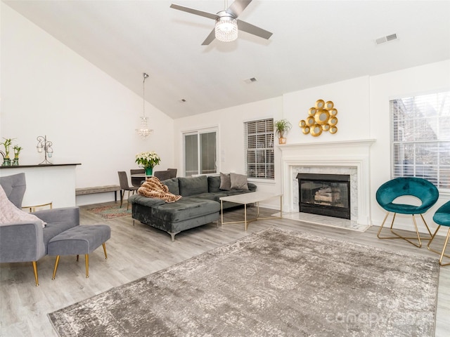 living room featuring ceiling fan, a fireplace, high vaulted ceiling, and hardwood / wood-style flooring