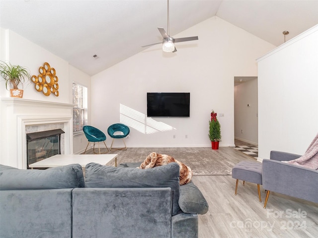 living room featuring a high end fireplace, hardwood / wood-style flooring, high vaulted ceiling, and ceiling fan