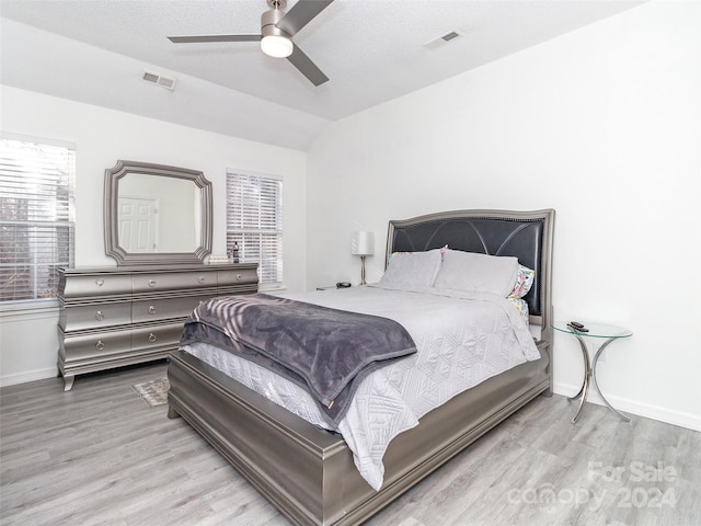 bedroom with light wood-type flooring, ceiling fan, and lofted ceiling