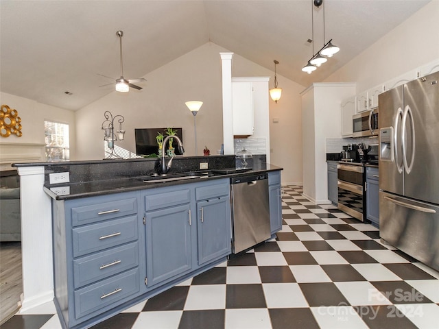 kitchen featuring lofted ceiling, white cabinets, blue cabinets, decorative backsplash, and appliances with stainless steel finishes