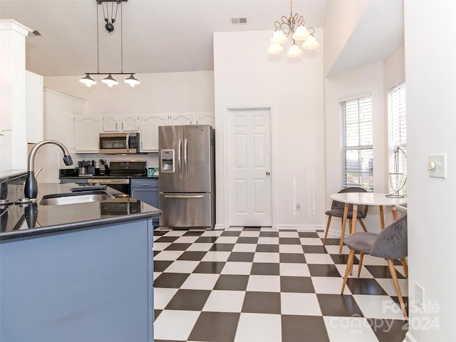 kitchen featuring white cabinetry, sink, hanging light fixtures, stainless steel appliances, and kitchen peninsula